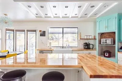 a kitchen with blue cabinets and a wooden counter top at Modern LakeHouse Sleeps 20 Hot Tub/Games/Fire Pit in Oakhurst