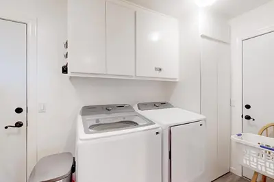 a white kitchen with a washing machine in it at Blue Skies & Bay Bliss in Carnelian Bay