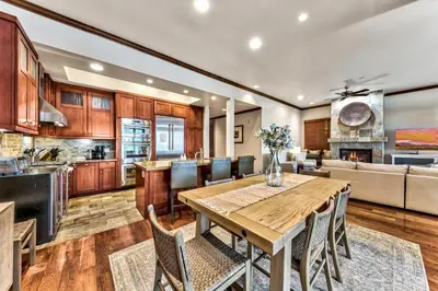 a kitchen and living room with a wooden table and chairs at Sierra Shores Five - Lakefront Comfort in South Lake Tahoe