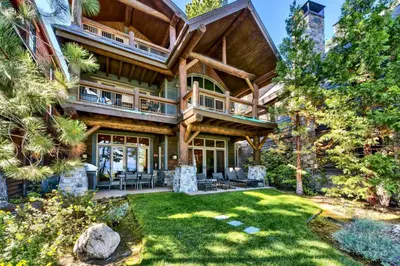 a log home with a large deck and lawn at Sierra Shores Five - Lakefront Comfort in South Lake Tahoe