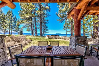a wooden table and chairs on a patio at The PEAK Denali 13 - The Ultimate in Lakefront Luxury in South Lake Tahoe