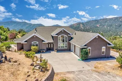 a home with a mountain in the background at Stargazing Retreat: fire pit/hot tub near Yosemite in Ahwahnee