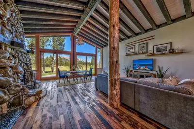 a living room with a couch and a stone wall at Duckhook at Tahoe in South Lake Tahoe
