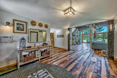 an empty living room with a mirror and a large window at Duckhook at Tahoe in South Lake Tahoe