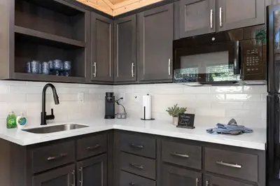 a kitchen with brown cabinets and a sink at Brand new Cabins in Kernville