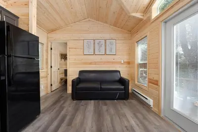 a black leather couch in a room with a window at Brandnew cabin in Kernville