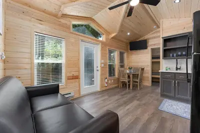 a living room with a leather couch in a log cabin at Brandnew cabin in Kernville