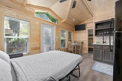 a bedroom with a bed in a room with wooden walls at Brandnew cabin in Kernville