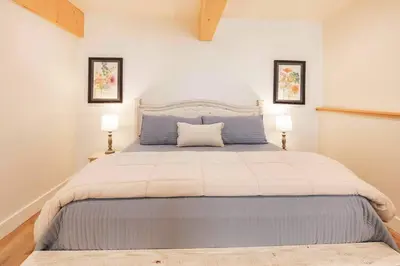 a bedroom with a large bed with two lamps at Timberwood Cottage in Downtown Twain Harte in Twain Harte