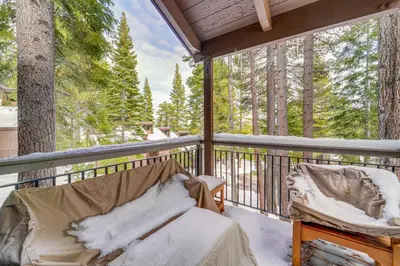 a porch with a bed and two chairs on a deck at Northstar Resort Condo with Hot Tub, Shuttle Access! in Truckee