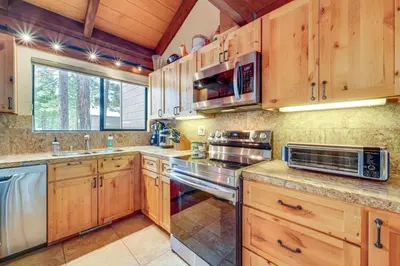 a kitchen with wooden cabinets and stainless steel appliances at Northstar Resort Condo with Hot Tub, Shuttle Access! in Truckee