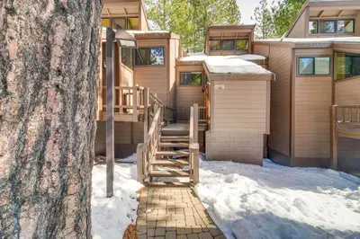 a house in the snow next to a tree at Northstar Resort Condo with Hot Tub, Shuttle Access! in Truckee