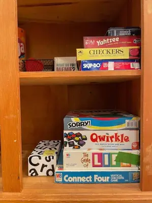 a book shelf filled with boxes of food at Cedar Oasis - Pet Friendly Cabin w Fireplace, Games and Wifi - 5 min to Big Trees in Arnold