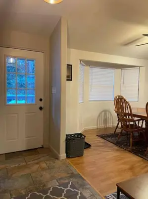 a living room with a dining table and a door at Cedar Oasis - Pet Friendly Cabin w Fireplace, Games and Wifi - 5 min to Big Trees in Arnold