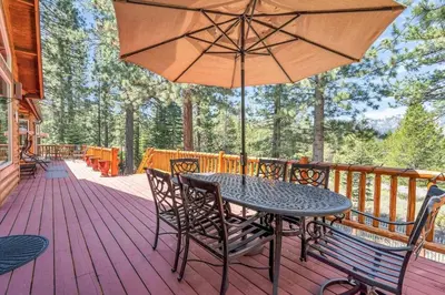 a table and chairs on a deck with an umbrella at 1603 Bel Aire Circle home in South Lake Tahoe