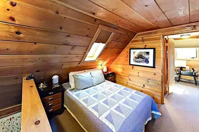 a bedroom with a bed in a wooden cabin at 3988 Manzanita Avenue cabin in South Lake Tahoe