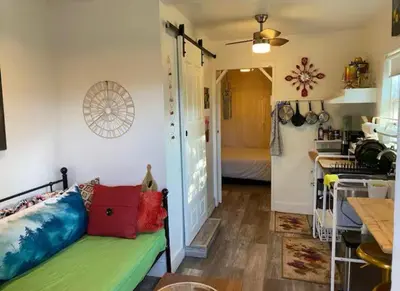 a living room with a green couch and a kitchen at Petite Guesthouse with Kitchenette and Private Bathroom in Lake Isabella