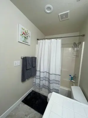 a white bathroom with a shower and a toilet at Sweet Holiday in Antelope