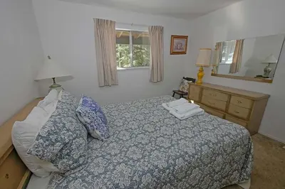 a bedroom with a bed and a dresser and a mirror at 1629 Pioneer Trail home in South Lake Tahoe
