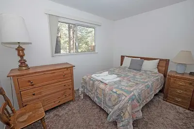 a bedroom with a bed and a dresser and a window at 1629 Pioneer Trail home in South Lake Tahoe