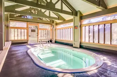 a hot tub in a large room with windows at Snowcreek 264 in Mammoth Lakes