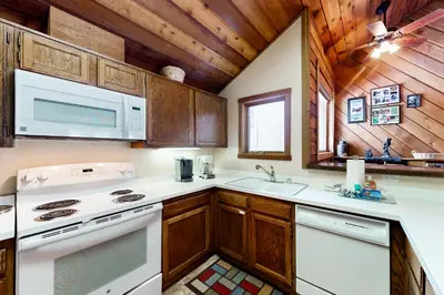 a kitchen with white appliances and wooden cabinets at Snowcreek 264 in Mammoth Lakes