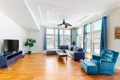 a living room with blue couches and a tv at Zerenity Lookout East in Oakhurst