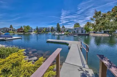 a dock in a lake with houses and boats at 1759 Venice Drive home in Tahoe Keys