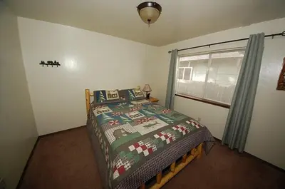 a bedroom with a bed with a comforter and a window at 1987 Cherokee St, home in South Lake Tahoe