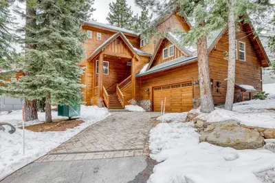 a log home in the snow with a driveway at Canterbury Lodge in Kings Beach
