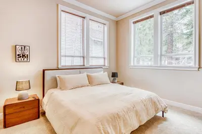 a bedroom with a bed and two windows at Canterbury Lodge in Kings Beach