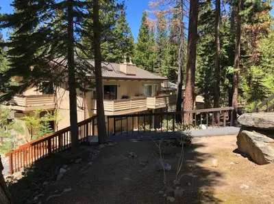 a house with a wooden fence in the woods at Fun & Air Conditioned Lake Tahoe 3 BR/2.5 BA Home in Incline Village