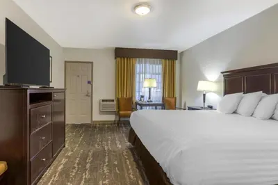 a hotel room with a large bed and a television at Best Western Frontier Motel in Lone Pine