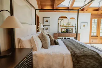 a bedroom with a large bed with a table at Luxury Nature Getaway Stone House by Casa Oso in Mariposa