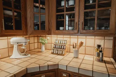 a kitchen counter with wooden cabinets and utensils at Luxury Nature Getaway Stone House by Casa Oso in Mariposa