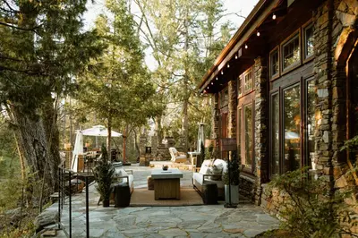 an outdoor patio with a couch and a table at Luxury Nature Getaway Stone House by Casa Oso in Mariposa