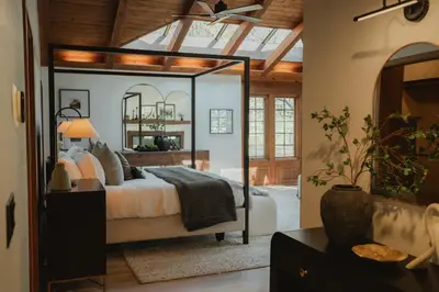 a bedroom with a bed with a large mirror at Luxury Nature Getaway Stone House by Casa Oso in Mariposa