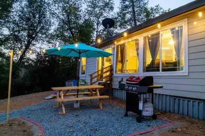 a picnic table with an umbrella and a grill at Yosemite's Scenic Hideaway in Midpines