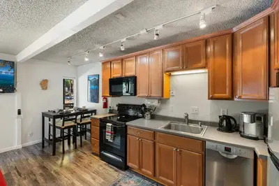 a kitchen with wooden cabinets and a sink and a table at Private/Cozy Kings Beach Retreat in Tahoe Vista