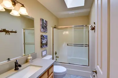 a bathroom with a shower and a toilet and a sink at Gas Grill and Pool Table Cabin Near Calaveras Park! in Arnold
