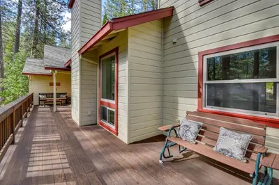 a wooden deck with a bench on the side of a house at Gas Grill and Pool Table Cabin Near Calaveras Park! in Arnold