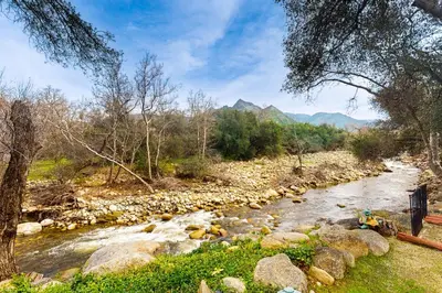 a river with rocks and trees and mountains in the background at Yard and Patio Quiet and Well-Stocked Riverside Home in Three Rivers