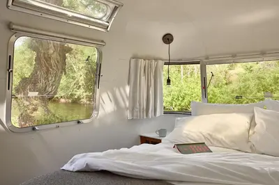 a bedroom with a bed and a large window at AutoCamp Sequoia in Three Rivers