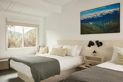 a white bedroom with two beds and a window at AutoCamp Sequoia in Three Rivers