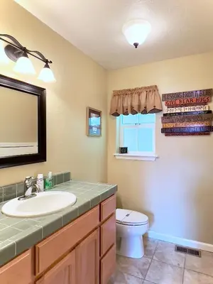 a bathroom with a sink and a toilet and a mirror at Anderson's Alpine Retreat- Pinecrest, CA Dodge Ski in Cold Springs