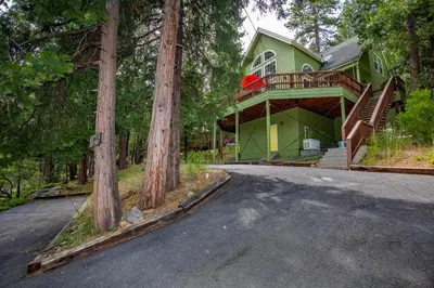 a green house with a deck on the side of a road at Anderson's Alpine Retreat- Pinecrest, CA Dodge Ski in Cold Springs