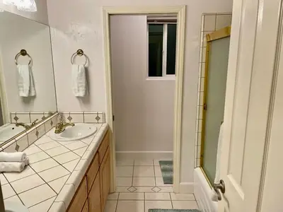 a white bathroom with a sink and a shower at Peacock House Sleeps 12 Hot Tub Game Room in Ahwahnee