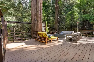 a wooden deck with a couch and chairs on it at Starlight Cabin in Oakhurst
