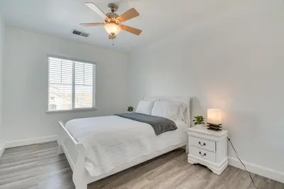 a white bedroom with a bed and a ceiling fan at 4 Mi to Dtwn Merced Spacious Home with Yard! in Merced