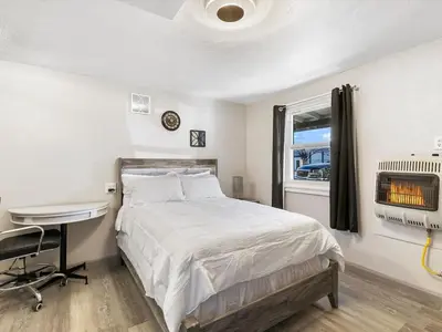 a bedroom with a bed and a desk and a window at Charming Retro Property 6 in Sparks